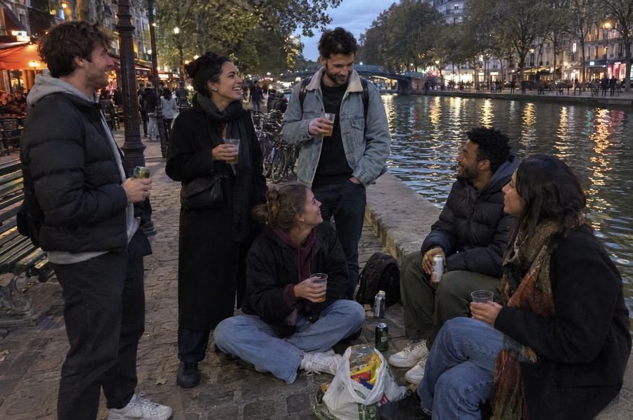 Six personnes prennent l'apéro au bord du canal Saint-Martin à la tombée de la nuit